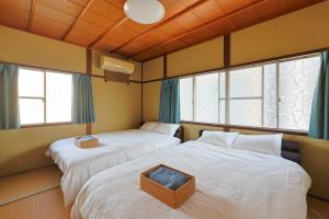 two beds in a room with two windows at Authentic Local Experience House in Nara