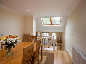 a dining room with a table and a vase of flowers at Oakridge in Salcombe