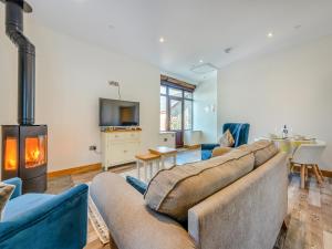 a living room with a couch and a fireplace at Ty Gwair - Uk41512 in Lampeter