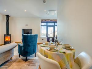 a dining room with a table and a fireplace at Ty Gwair - Uk41512 in Lampeter