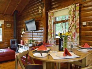 a dining room with a table in a log cabin at Forest View in Strathyre
