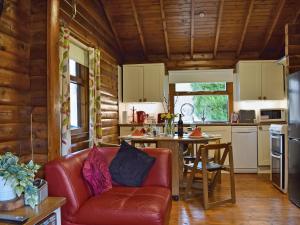 a living room with a couch and a table in a kitchen at Forest View in Strathyre