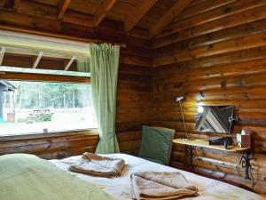 a bedroom with a bed and a desk and a window at Forest View in Strathyre