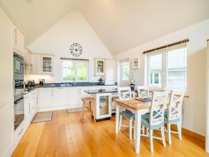 a kitchen with a table and chairs and a clock on the wall at Twill Lodge - 4 Swandown in Cudworth