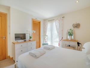 a white bedroom with a white bed and a television at Twill Lodge - 4 Swandown in Cudworth