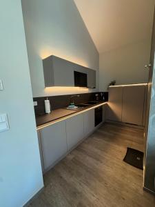 a small kitchen with white cabinets and a tv at Stilapartment Loft #Whirlpool saisonal in Wernigerode +8 photos