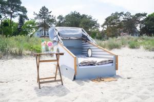a play house on the beach with a table at Schlafstrandkorb Nr 8 in Timmendorfer Strand