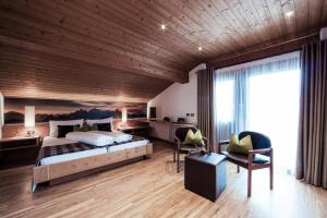 a bedroom with a large bed with a wooden ceiling at SIEGI apartments & retreat - Merano Südtirol in Parcines
