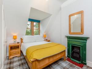 a bedroom with a bed and a fireplace at Gardeners Cottage in Huntly