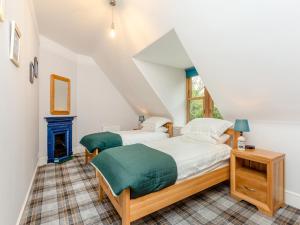 two beds in a attic bedroom with a fireplace at Gardeners Cottage in Huntly +13 photos