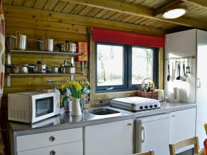 a kitchen with a microwave and a sink at Kestrel Cabin - Uk1246 in Westward