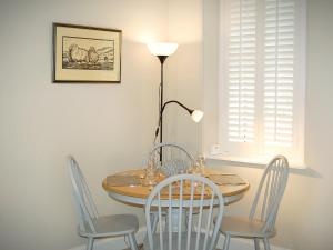 a dining room table with chairs and a lamp at Summergate Cottage in Annan