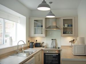 a kitchen with a sink and a microwave at Summergate Cottage in Annan