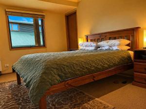a bedroom with a large bed and a window at Dragonfly Chalet in Dinner Plain