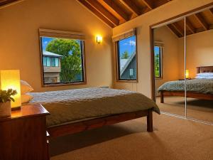 a bedroom with a bed and two windows at Dragonfly Chalet in Dinner Plain