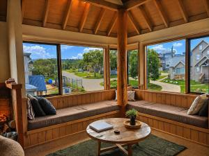 a screened in porch with a table and windows at Dragonfly Chalet in Dinner Plain