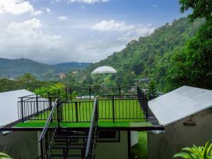 a balcony with an umbrella on top of a house at Blue Sky Monjam in Chiang Mai