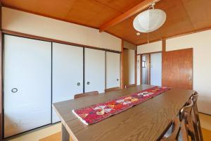 a dining room with a wooden table with chairs at Authentic Local Experience House in Nara