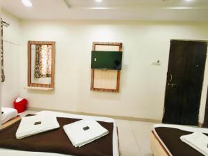 a room with a bed and a tv on the wall at Sai Tara Residency in Shirdi +6 photos