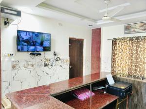 a room with a tv on the wall at Sai Tara Residency in Shirdi