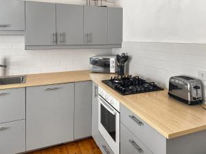 a kitchen with white cabinets and a stove top oven at Nautilus in St Ives