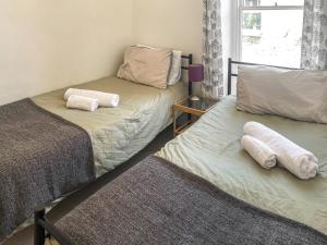 two beds in a room with towels on them at Nautilus in St Ives