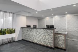 an office lobby with a stone reception counter with chairs at Homewood Suites Williamsburg in Williamsburg +33 photos