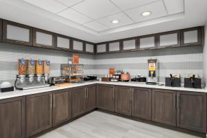 a kitchen with wooden cabinets and aasteryasteryasteryasteryasteryasteryasteryasteryastery at Homewood Suites Williamsburg in Williamsburg