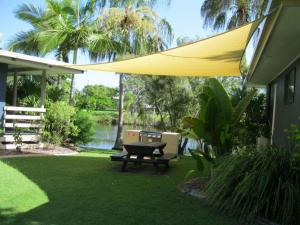 a patio with a picnic table and a yellow umbrella at Waters Edge in Urangan