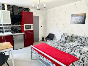 a bedroom with a bed and a red kitchen at La Petalerie Appartements d'hôtes in Épernay