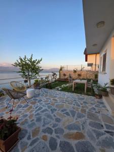 a stone patio with a view of the water at Pelikan Lake House in Shkodër