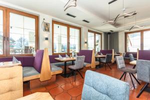 a restaurant with tables and chairs and windows at Apart Hotel Alpenhof Werfenweng in Werfenweng