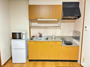 a small kitchen with a sink and a refrigerator at メゾンドyy寺田 アパート1室貸切 素泊まり最大6人宿泊可能 4名様まで同一料金 in Yamaguchi