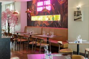 a row of tables in a restaurant with pink walls at DoubleTree by Hilton Dartford Bridge in Dartford