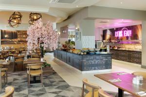 a restaurant with tables and chairs and a buffet at DoubleTree by Hilton Dartford Bridge in Dartford
