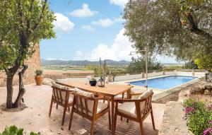 a wooden table and chairs next to a swimming pool at Villa Torre Bes in San Antonio