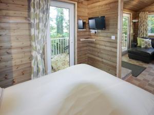 a bedroom with a large bed and a balcony at Treehouse Cabin in Westward