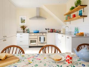 a kitchen with a table with a tablecloth on it at West Skeroblin in Campbeltown +11 photos