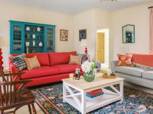 a living room with a red couch and a table at West Skeroblin in Campbeltown
