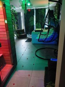 a room with a hammock in a room with plants at Ô Spa Privatif - Luxury Suite - JACUZZI-SAUNA-NETFLIX-FISHSPA-SERVIETTES-PEIGNOIRS-SANDALES-CAFE in Morlanwelz-Mariemont