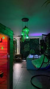 a living room with a green and red lighting at Ô Spa Privatif - Luxury Suite - JACUZZI-SAUNA-NETFLIX-FISHSPA-SERVIETTES-PEIGNOIRS-SANDALES-CAFE in Morlanwelz-Mariemont