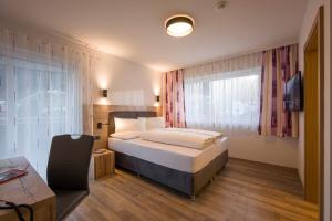 a hotel room with a bed and a window at Aparthotel AlpTirol in Kaltenbach