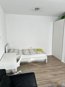 a white bedroom with a bed and a chair at Modernes 3-Zimmer Appartement in Wels