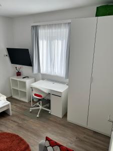 a white office with a desk and a window at Modernes 3-Zimmer Appartement in Wels +16 photos