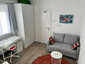 a small living room with a couch and a desk at Modernes 3-Zimmer Appartement in Wels