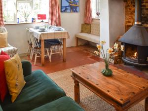 a living room with a couch and a table with a fireplace at The Buttery in Buxton