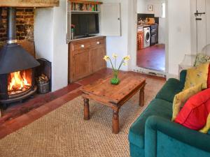 a living room with a couch and a coffee table with a fireplace at The Buttery in Buxton