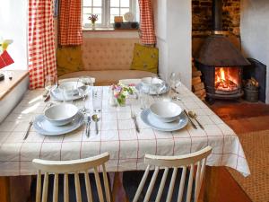 a table with plates and bowls and a fireplace at The Buttery in Buxton