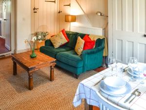 a living room with a green couch and a table at The Buttery in Buxton +15 photos