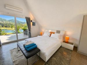 a bedroom with a large bed and a large window at Royal Shell by Utalay Koh Chang in Ban Khlong Son
